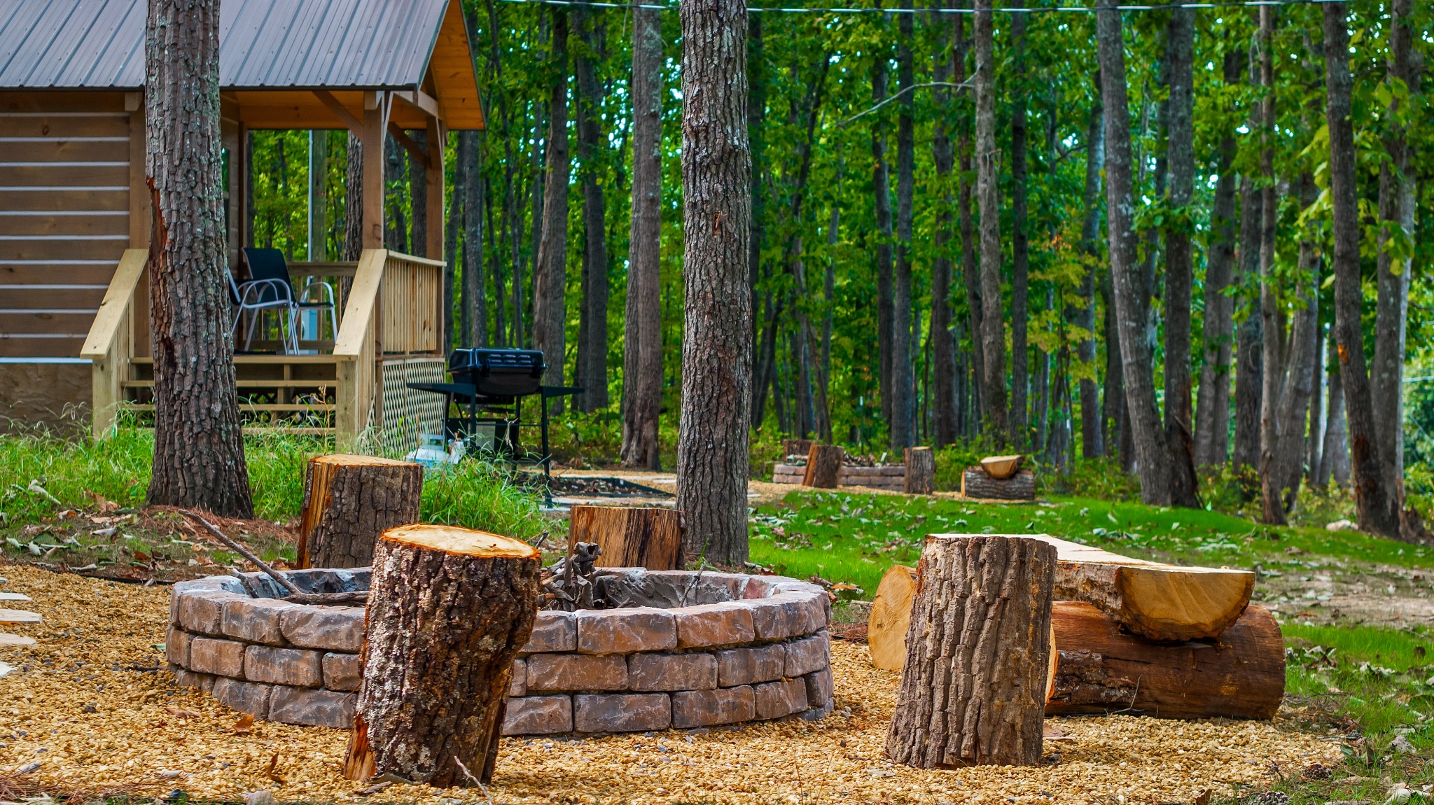 Fire pit and seating area beside a log cabin