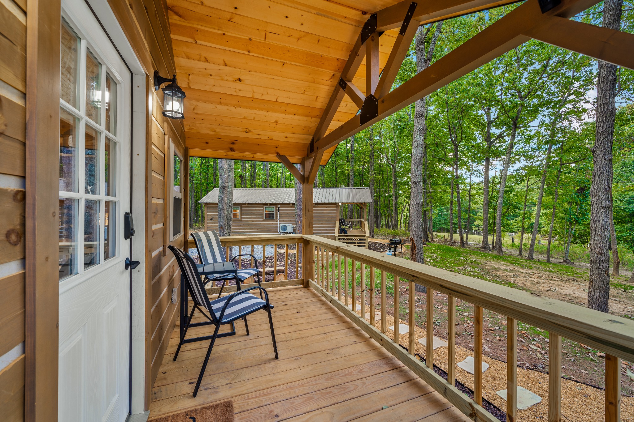 Covered cabin porch with chairs overlooking the woods